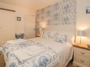 A bedroom with a double bed bedside tables lamps and a door at Hillcrest in Scarborough