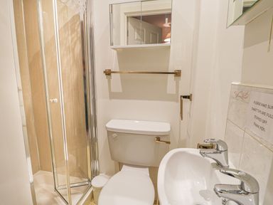 A small bathroom with a shower enclosure toilet sink and mirror at Hillcrest in Scarborough