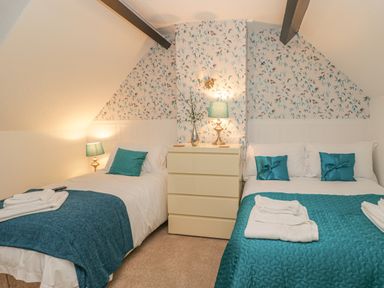 A bedroom with two beds a chest of drawers and two lamps at Hillcrest in Scarborough
