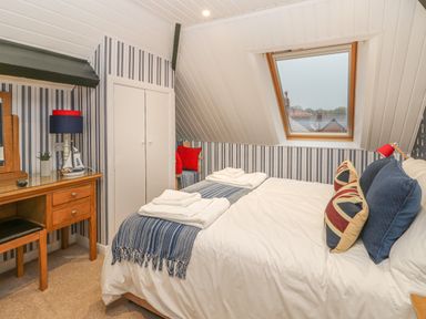 A bedroom with a double bed a skylight window and a wooden dressing table at Hillcrest in Scarborough