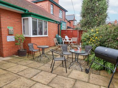 An outdoor patio area with tables and chairs a barbecue and plants at Hillcrest in Scarborough