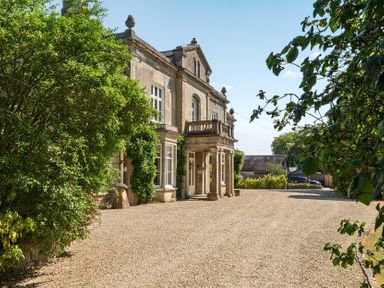 A house with a balcony and gravel driveway at Milton Manor in Milton On Stour
