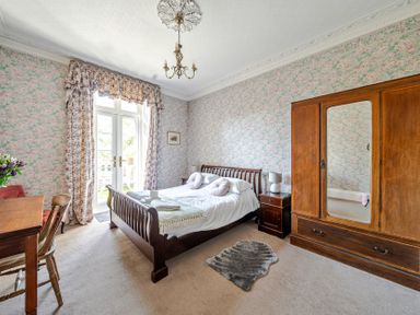 A bedroom with a bed and wardrobe at Milton Manor in Milton On Stour
