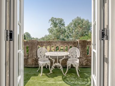 A balcony with a table and chairs at Milton Manor in Milton On Stour