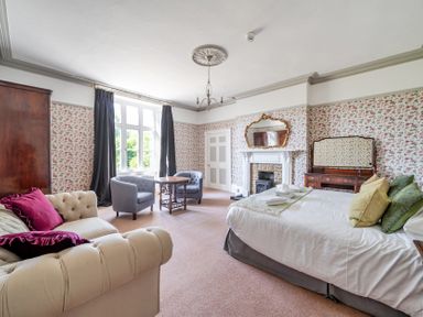 A bedroom with a bed, sofa and seating area at Milton Manor in Milton On Stour