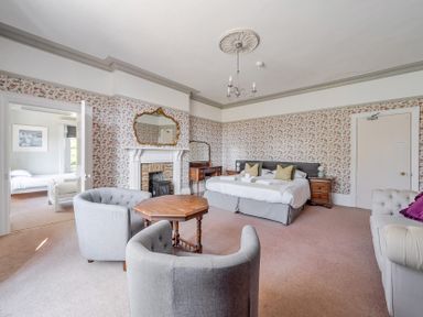 A bedroom with beds and a table at Milton Manor in Milton On Stour
