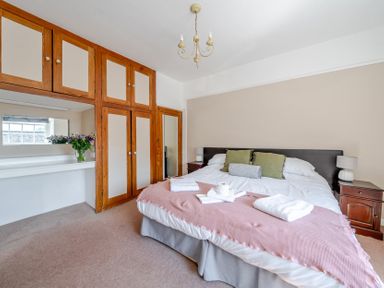 A bedroom with a bed and a mirror at Milton Manor in Milton On Stour