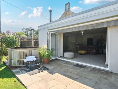 An outdoor area with a hot tub and sliding doors at Milton Manor in Milton On Stour