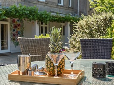 An outdoor area with a tray, pineapple and glassware at Milton Manor Milton On Stour