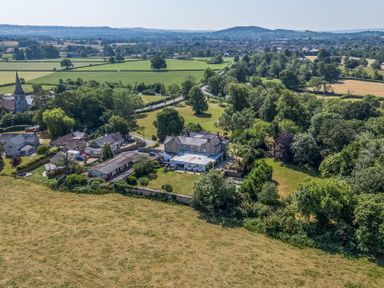 An aerial view of a village with houses and fields at Milton Manor in Milton On Stour