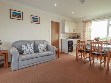 A living room with a sofa and dining area at Little Lanes in Boscastle