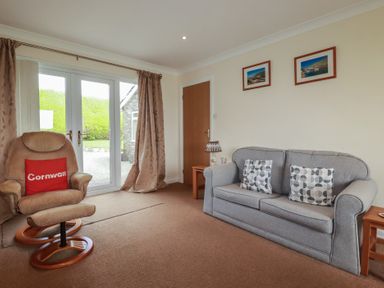 A living room with a sofa and armchair at Little Lanes in Boscastle