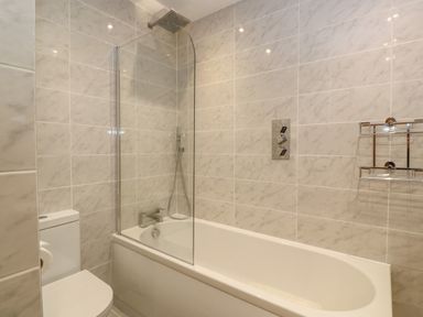 A bathroom with a bathtub shower combination and a toilet at 1 River View in Looe