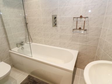 A bathroom with a bathtub shower combination toilet and a sink at 1 River View in Looe