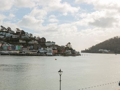 A waterfront with houses on a hillside and a body of water at 2 Embankment House in Dartmouth