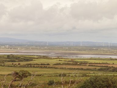 A rural landscape with fields bushes wind turbines and scattered houses at Newtown East near Kilkee County Clare