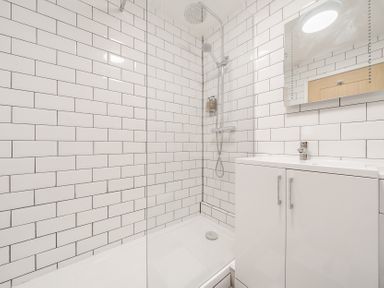 A bathroom with a shower area and white subway tiles at The Boars Head Pub in Bishops Castle