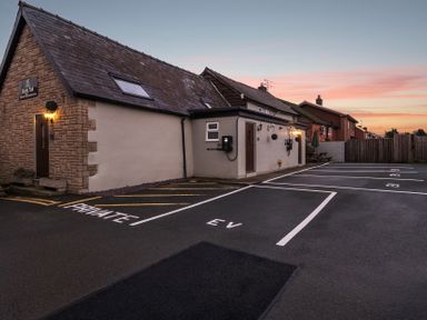 An outdoor area with parking spaces and a building at The Boars Head Pub in Bishop's Castle