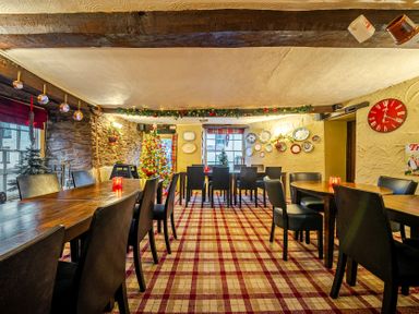 A dining room with wooden tables and chairs at The Boars Head Pub in Bishop's Castle