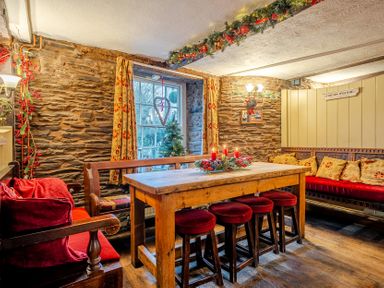 A dining room with a wooden table and stools at The Boars Head Pub in Bishop's Castle