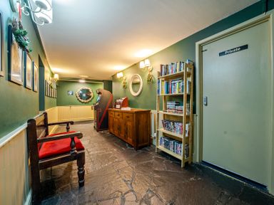 A hallway with a bench and bookshelf at The Boars Head Pub in Bishop's Castle