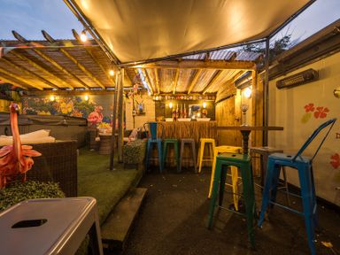 An outdoor seating area with bar stools and a table at The Boars Head Pub in Bishop's Castle