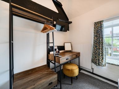 A bedroom with a desk and wardrobe at The Boars Head Pub in Bishop's Castle