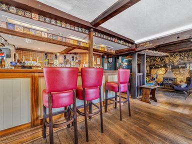 A bar with stools and beer taps at The Boars Head Pub in Bishop's Castle