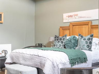 A bedroom with a bed, pillows, and a lamp at The Boars Head Pub in Bishop's Castle