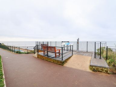 A lookout platform with benches and a telescope overlooking the sea at Little Wash Cottage in Hunstanton