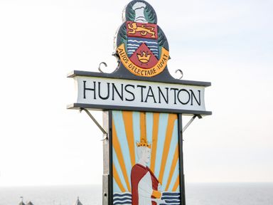 A decorative town sign with a coat of arms and the word Hunstanton by the sea
