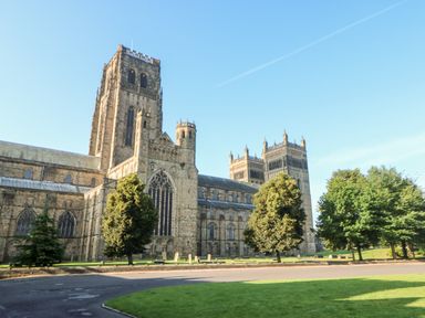 A large stone cathedral with tall towers surrounded by trees and green grass at Badgers Sett in Winston near Staindrop