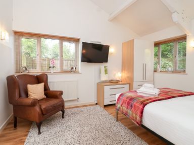 A bedroom with a bed and armchair at Tregona Buckland Monachorum near Yelverton
