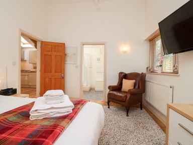 A bedroom with a bed and chair at Tregona Buckland Monachorum near Yelverton