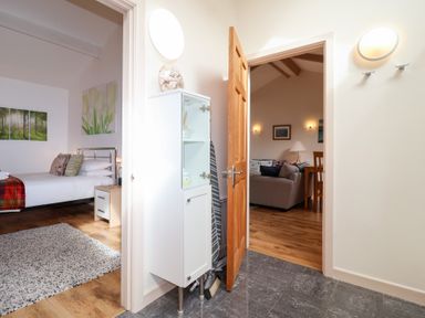 A bedroom with a bed and a doorway leading to a living area at Tregona Buckland Monachorum near Yelverton