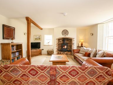 A living room with a fireplace wooden coffee table sofas and a television at Shifford Manor Farm in Shifford near Bampton Oxfordshire