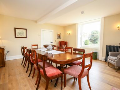 A dining room with a wooden table and chairs near a large window at Shifford Manor Farm Shifford near Bampton Oxfordshire