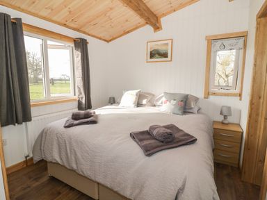 A bedroom with a bed towels bedside tables and windows at Top Style Orchard in Hallow