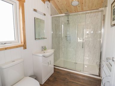 A bathroom with a toilet sink mirror shower enclosure and window at Top Style Orchard in Hallow