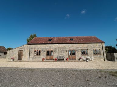 A stone building with a front door and windows at Bramble Cottage in Somerton