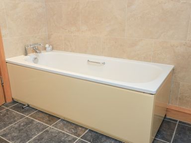 A bathtub with faucet in a bathroom at Bramble Cottage, Babcary near Lydford-On-Fosse