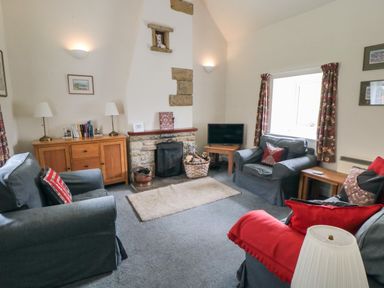 A sitting room with three armchairs a wooden sideboard and a TV on a small wooden table at Silver Birches in Glaisdale