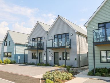 A row of modern two story houses with balconies and small gardens at Devonair in Westward Ho