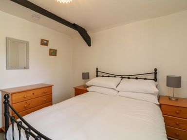 A bedroom with a double bed and wooden furniture at The Stable in Bude