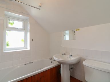 A bathroom with a bathtub a sink and a toilet at The Stable in Bude