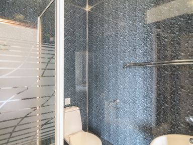 A bathroom with a toilet shower enclosure and sink at The Dairy in Bude