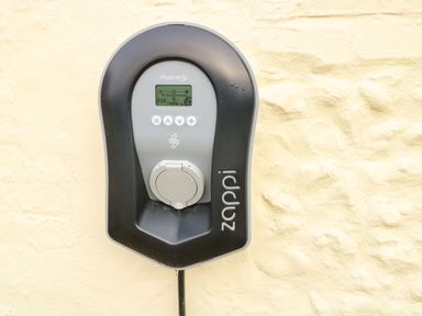 An electric vehicle charging station mounted on an exterior wall at Primrose Cottage in Stiffkey