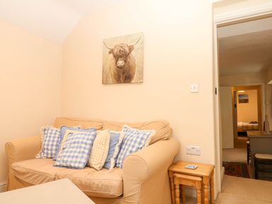 A living room with a sofa and painting at Yew Tree Cottage Stoke Fleming