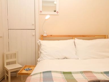 A bedroom with a bed and lamp at Yew Tree Cottage Stoke Fleming