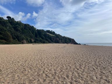 A beach with sand and hills at Yew Tree Cottage in Stoke Fleming